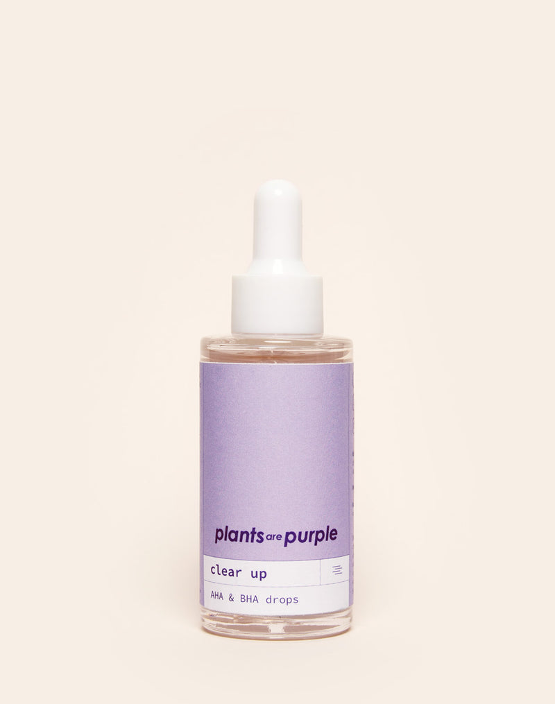 Dropper bottle of skincare serum labeled 'plants are purple, clear up, AHA & BHA drops.'